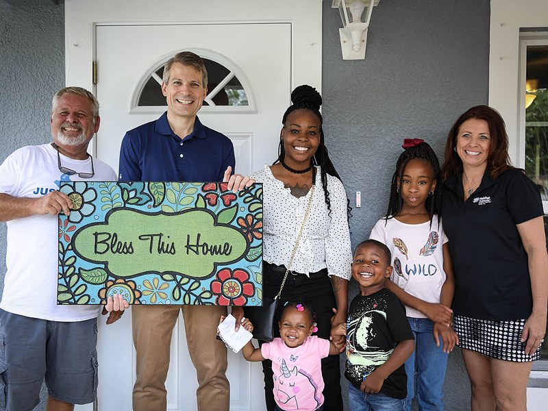 family on front porch of habitat for humanity home in Tampa Bay Florida