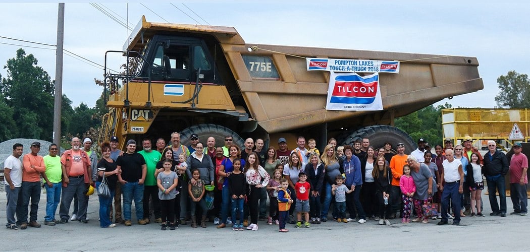 community in font of dump truck